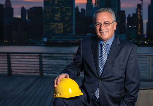 Vebi Barami, owner of Barami Construction Group,  stands in front of the New York City skyline.
